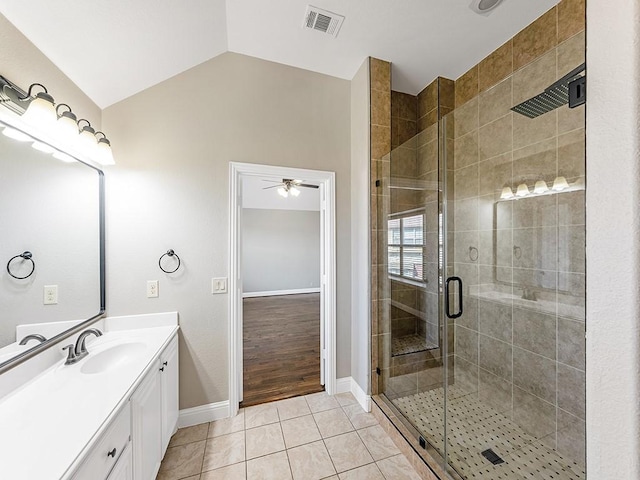 full bathroom featuring lofted ceiling, vanity, visible vents, tile patterned floors, and a stall shower