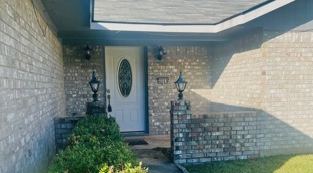 entrance to property featuring brick siding