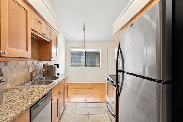 kitchen with pendant lighting, light tile patterned floors, backsplash, appliances with stainless steel finishes, and a sink