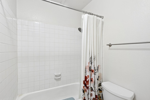 bathroom with shower / bathtub combination with curtain and toilet