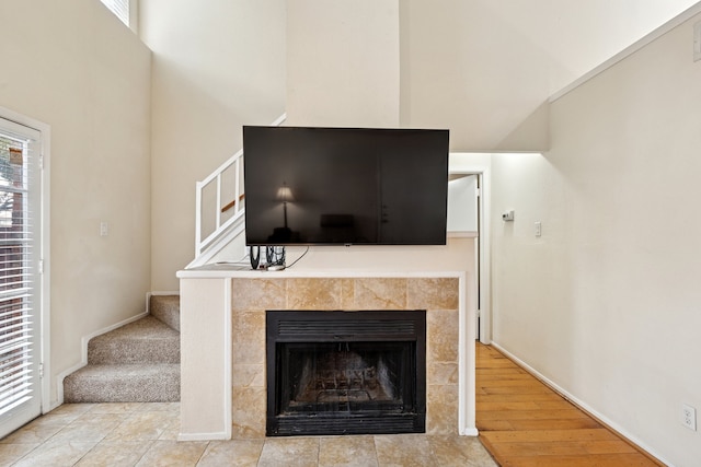 interior details with a tile fireplace and wood finished floors