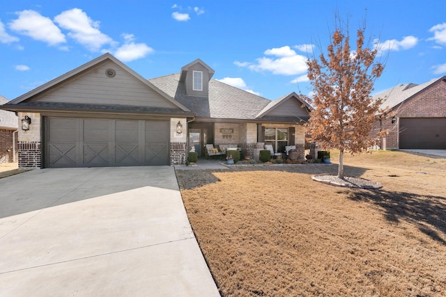 view of front of house featuring a garage, a shingled roof, concrete driveway, and brick siding