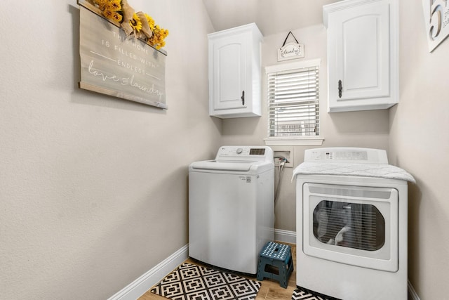 clothes washing area with cabinet space, independent washer and dryer, and baseboards