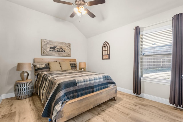 bedroom with a ceiling fan, lofted ceiling, baseboards, and wood finished floors