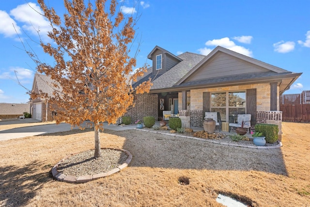 view of front of property featuring fence, a porch, and roof with shingles