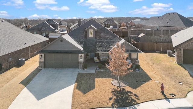 view of front of home featuring central air condition unit, a residential view, and concrete driveway