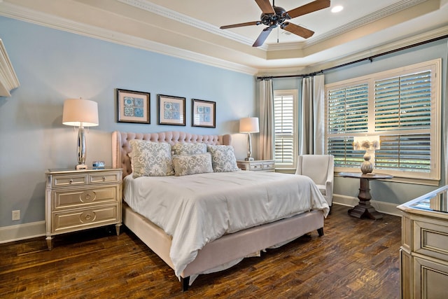 bedroom with dark wood-style floors, a raised ceiling, ornamental molding, a ceiling fan, and baseboards