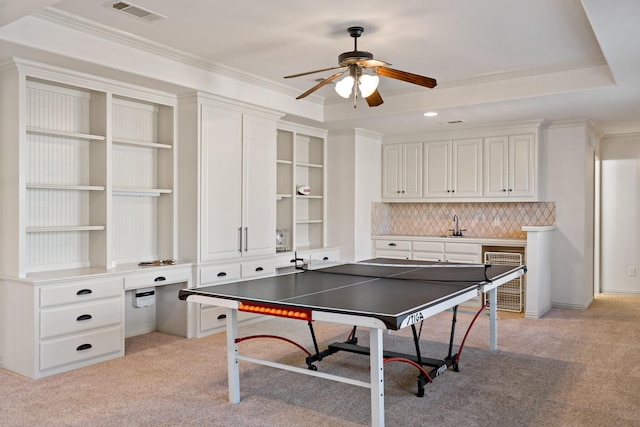 game room featuring a raised ceiling, visible vents, crown molding, and light carpet