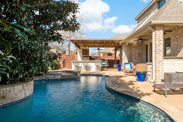 view of swimming pool featuring a patio, outdoor dry bar, a pool with connected hot tub, fence, and ceiling fan