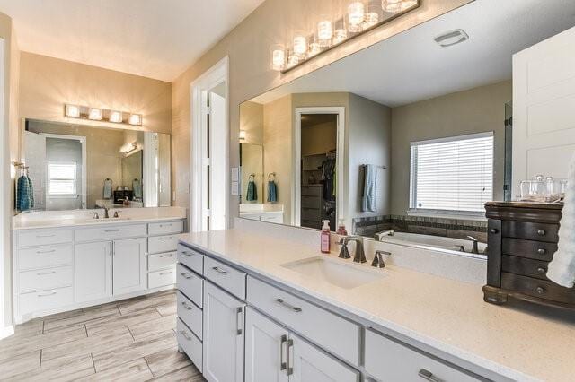 bathroom with two vanities, a sink, visible vents, and wood tiled floor