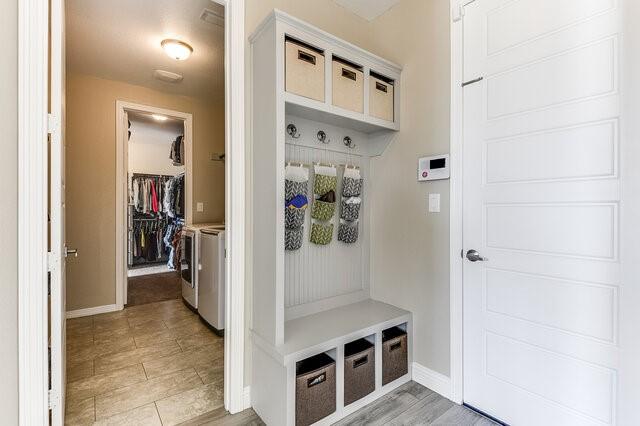 mudroom with washer and clothes dryer and baseboards