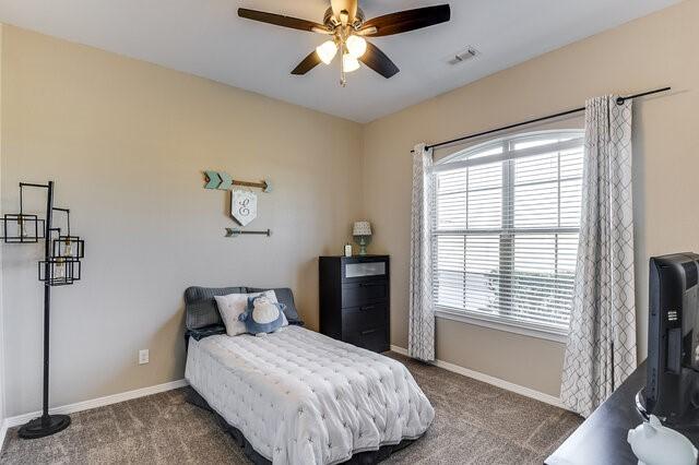 bedroom featuring carpet flooring, ceiling fan, visible vents, and baseboards