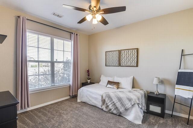 bedroom with a ceiling fan, carpet, visible vents, and baseboards