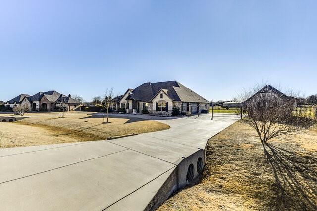 view of front facade featuring concrete driveway and a front lawn