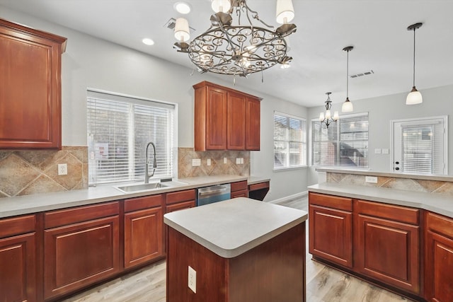 kitchen featuring visible vents, a sink, a notable chandelier, light countertops, and stainless steel dishwasher