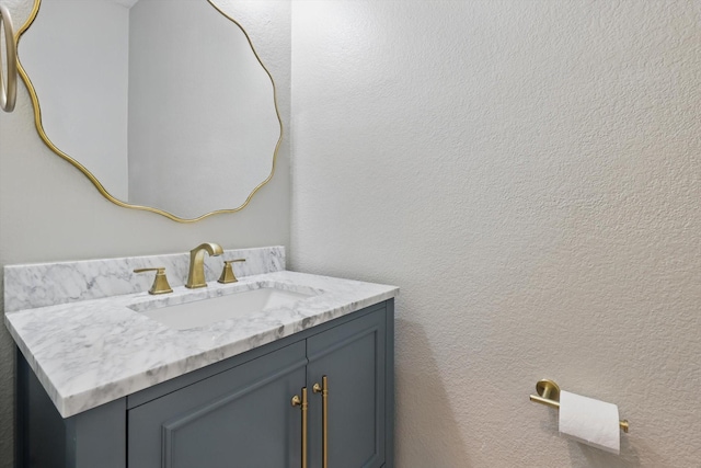 bathroom featuring a textured wall and vanity