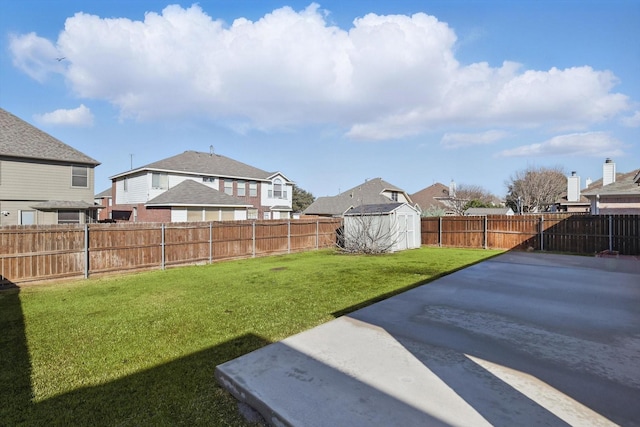 view of yard with an outbuilding, a fenced backyard, a residential view, a shed, and a patio area