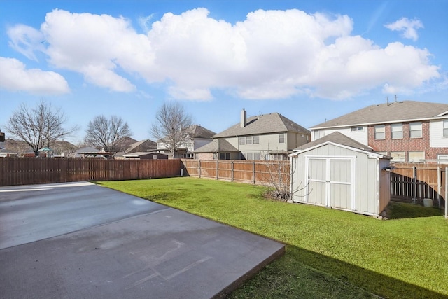 view of yard with an outbuilding, a patio, a fenced backyard, and a residential view