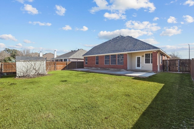 back of property with brick siding, a lawn, a patio area, and a fenced backyard