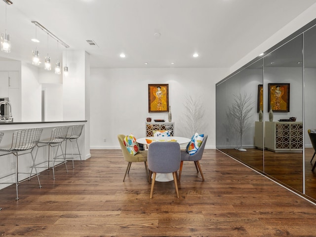 dining room featuring baseboards, wood finished floors, and recessed lighting