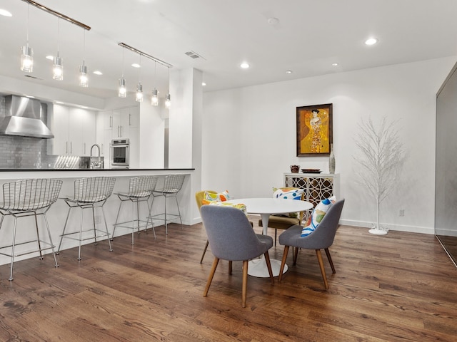 dining space with baseboards, visible vents, wood finished floors, and recessed lighting