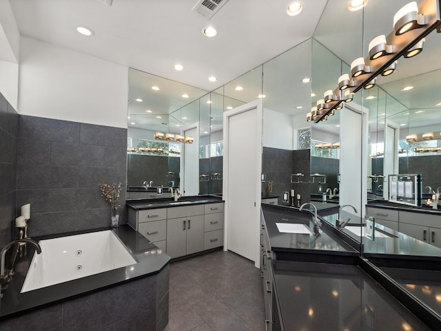 full bathroom featuring two vanities, visible vents, a sink, and a jetted tub