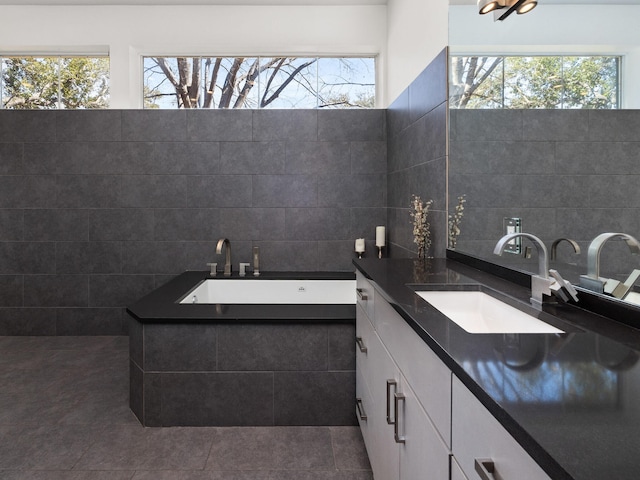 bathroom featuring tile patterned flooring, tile walls, vanity, and a bath