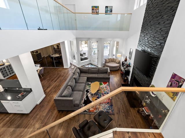 living area featuring a towering ceiling and wood finished floors