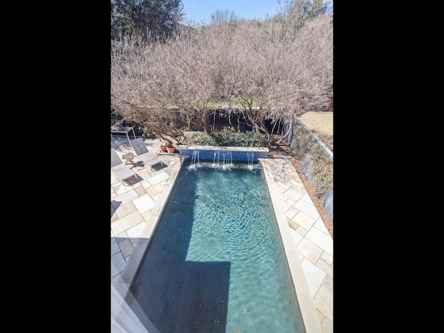 outdoor pool featuring a patio area and a fenced backyard