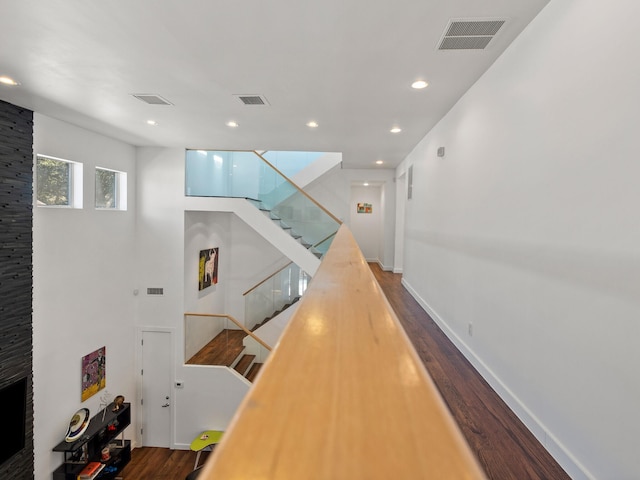 hall with stairway, wood finished floors, visible vents, and recessed lighting