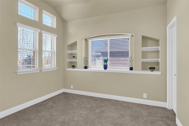 empty room featuring carpet floors, baseboards, built in features, and vaulted ceiling