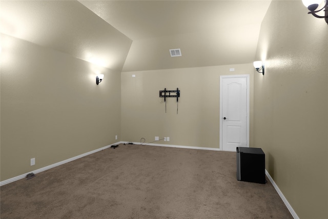 spare room featuring lofted ceiling, carpet, visible vents, and baseboards