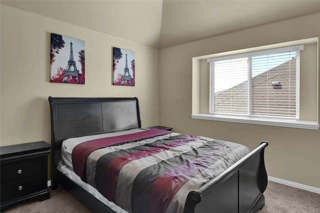 carpeted bedroom featuring lofted ceiling and baseboards