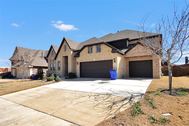 view of front of house featuring brick siding, fence, driveway, stone siding, and roof with shingles