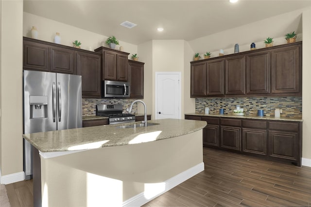 kitchen with a sink, visible vents, dark brown cabinets, appliances with stainless steel finishes, and dark wood finished floors