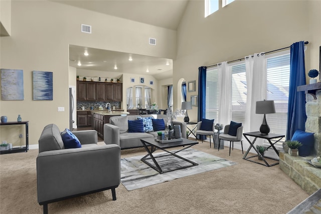 living room with light carpet, a high ceiling, and visible vents