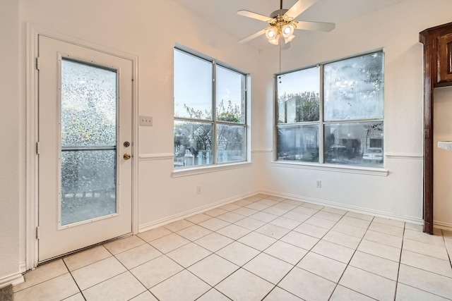 entryway featuring a ceiling fan, baseboards, and light tile patterned floors