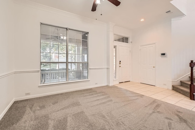 interior space with crown molding, tile patterned floors, a ceiling fan, baseboards, and stairs