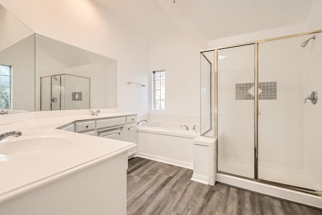 full bath with a stall shower, a garden tub, vanity, and wood finished floors