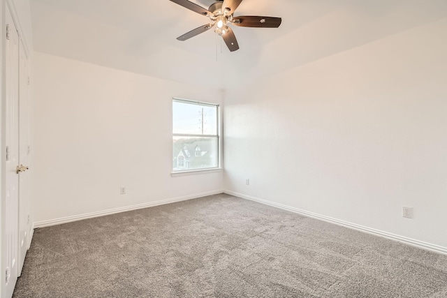 carpeted empty room featuring a ceiling fan and baseboards