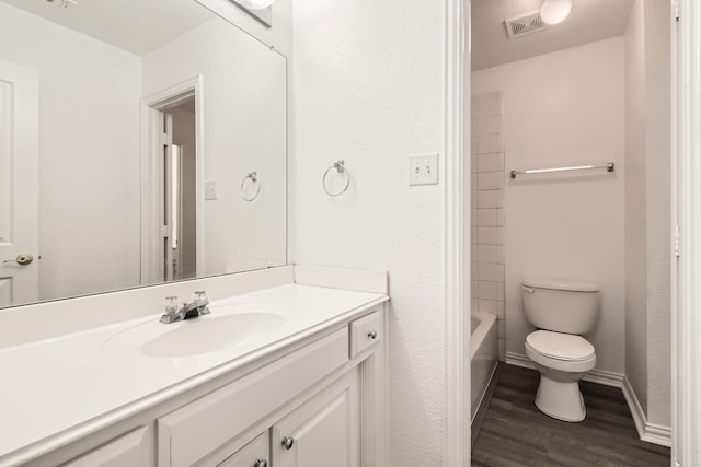 full bath with baseboards, visible vents, toilet, wood finished floors, and vanity