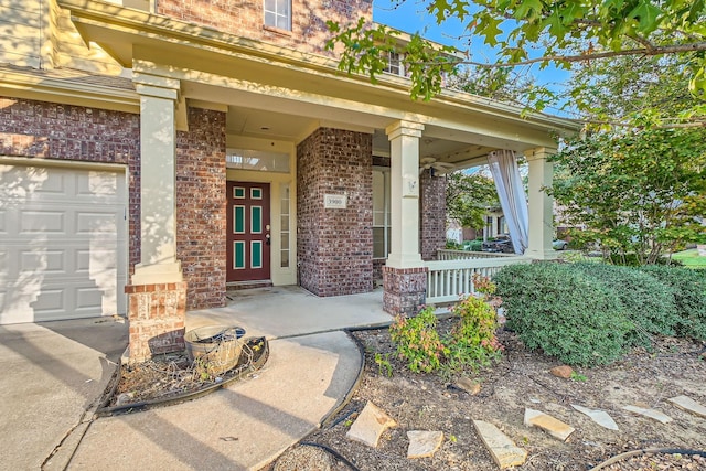 view of exterior entry featuring covered porch and brick siding