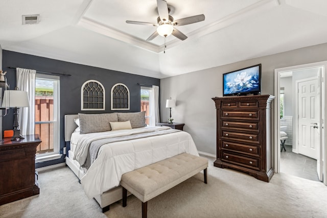 bedroom with ceiling fan, a tray ceiling, multiple windows, and light colored carpet