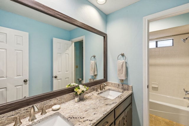 bathroom featuring bathtub / shower combination, a sink, and double vanity