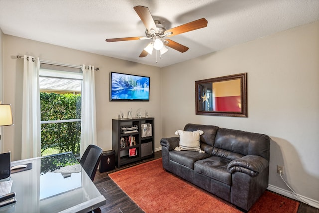 office area with dark wood finished floors, a textured ceiling, baseboards, and ceiling fan