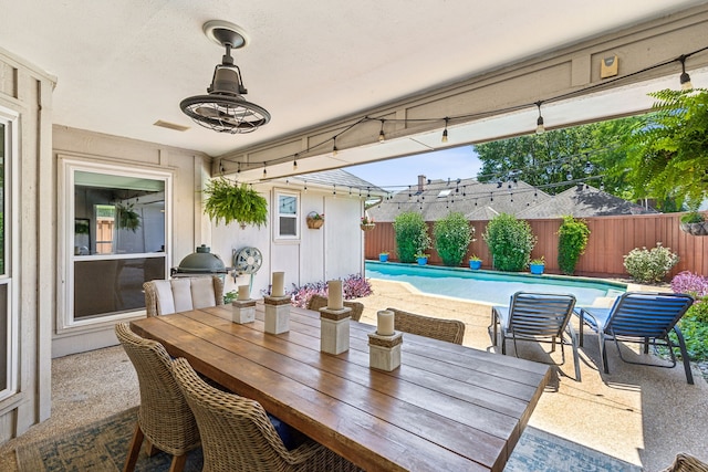 view of patio / terrace with a fenced in pool, outdoor dining space, a fenced backyard, and area for grilling