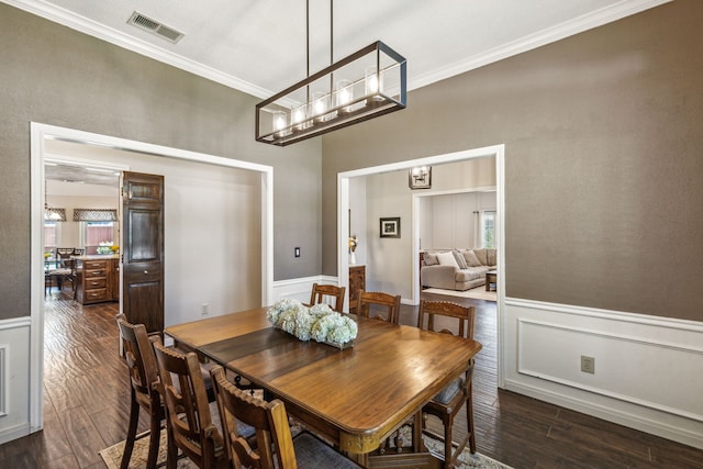 dining room with a wainscoted wall, visible vents, ornamental molding, dark wood-style floors, and plenty of natural light