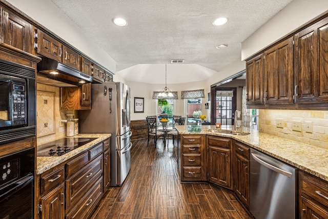 kitchen with wood finish floors, visible vents, a sink, under cabinet range hood, and black appliances