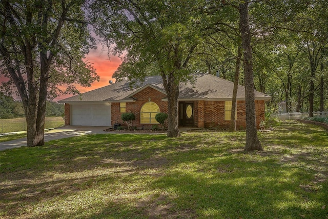 ranch-style house featuring fence, a lawn, and brick siding