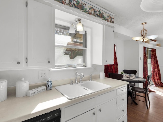 kitchen with a chandelier, a sink, white cabinetry, and dishwasher